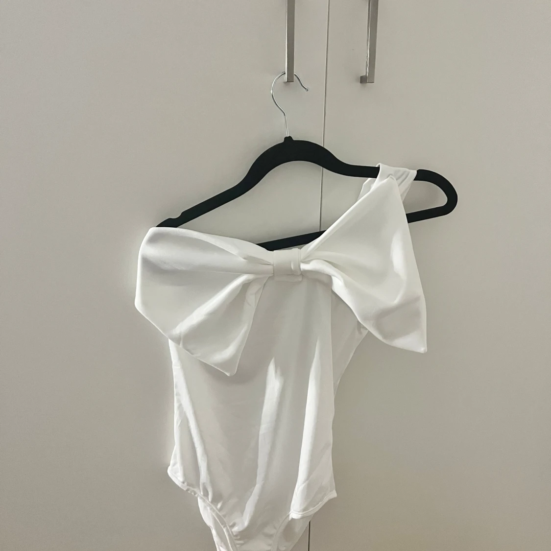 Vit oneshoulder body med stor rosett - 1