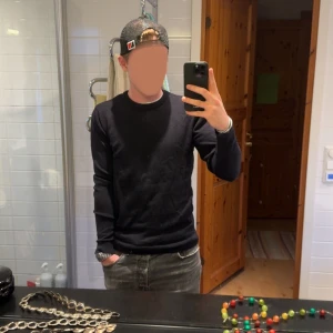 Mörkblå långärmad tröja i Merinoull  - En stilren mörkblå långärmad tröja i mjuk merinoull. Enkel och clean design utan tryck eller mönster, perfekt att matcha med jeans eller andra byxor. Rund halsringning och normal passform för en avslappnad look.