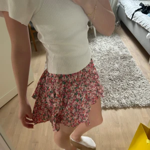 Blommig volangkjol från Zara  - Supersöt kort kjol med blommigt mönster i rosa, grönt och vitt, kjolen är från Zara🩷