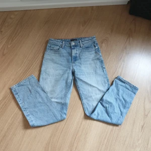 Ljusblå jeans från Tommy Hilfiger - Snygga ljusblå jeans från Tommy Hilfiger med klassisk femficksdesign och broderad logga på bakfickan. Jeansen har raka ben och normal passform, tillverkade i slitstarkt bomullsjeans. Perfekta för en avslappnad och trendig look.