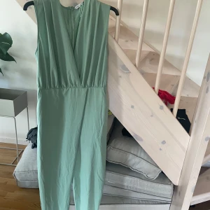 Mintgrön byxdress från Zara XS - Snygg mintgrön byxdress från Zara i storlek XS. Ärmlös modell med omlott framtill och markerad midja. Lätt och skönt material som ger en fräsch look. Perfekt för dig som gillar stilrena plagg med modern känsla.