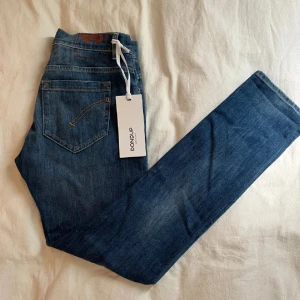 Dondup George - Riktigt populära dondup jeans med slim passform och klassisk femficksdesign för billigt pris. Perfekta för en avslappnad och stilren vardagsstil, packad och redo att skickas!       Nypris: 3000, mitt pris: 500.                              Passar 170 och uppåt. Modellen är 178. 