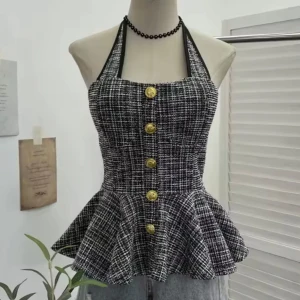 Svartvit peplum toppar  med knappar  - Säljer en svartvit rutig klänning med halterneck och dekorativa guldknappar framtill. Klänningen har en utställd kjol och markerad midja för en feminin siluett. Perfekt för dig som gillar klassisk stil med en twist.              Stl M men liten som S 