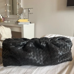 Svart flätad kuvertväska Gina Tricot - Säljer en svart kuvertväska från Gina Tricot i snyggt flätat skinnimitation. Väskan har magnetlås och innerfack med dragkedja. 