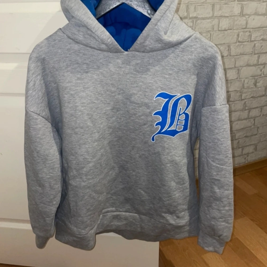 Grå hoodie med blå bokstavstryck