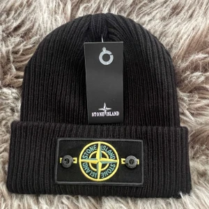 Stone Island mössa  - Svart ribbstickad mössa från Stone Island med uppvikt kant. Pris går att diskuteras