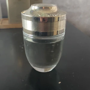 Paco Rabanne Invictus parfym - Säljer en flaska Invictus parfym från Paco Rabanne. Flaskan är genomskinlig med en silvrig, metallisk kork och har en modern, sportig design. Parfymen är känd för sin fräscha och maskulina doft. Perfekt för dig som gillar stilrena och snygga flaskor.