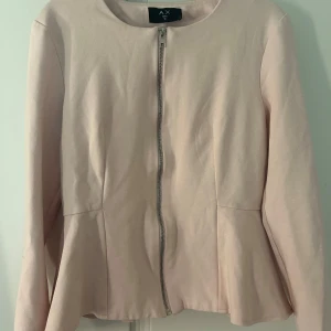 Ljusrosa kofta från AX Paris - Snygg ljusrosa kofta från AX Paris med rund halsringning och dragkedja framtill. Jackan har en feminin, lätt utsvängd form nedtill och är helfärgad utan mönster. Perfekt för dig som vill ha en stilren och chic look. Väldigt snygg passform. Storlek S/M💗