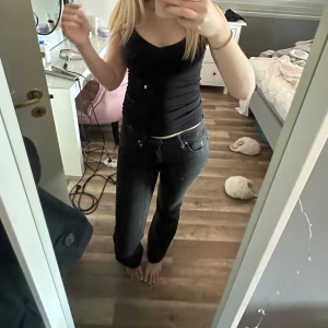 Grå svarta jeans  - Säljer ett par grå svarta jeans från PACE med snygg röd patch bak i midjan och klassiska orange sömmar. Jeansen har rak passform och normal midja, med en liten ficka framtill och diskret  PACE-logga. Storleken är w28 och l32