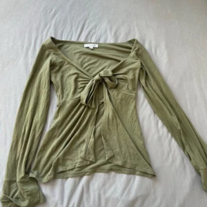 Olivgrön design by si topp - Supersnygg olivgrön omlottopp med långa ärmar och knyt framtill från design by si i storlek xs/s