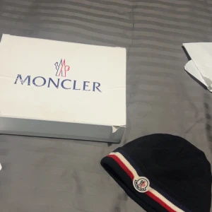 Moncler mössa  - Säljer min moncler mössa som är i mycket bra skick men qr koden är lite förstörd då jag lagt in i tvätten priset kan diskuteras vid snabb affär. (ÄKTA)
