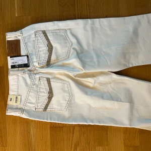 Vita bootcut jeans från Levi's 26/32 - Snygga vita Levi's jeans i bootcut-modell med klassiska bakfickor och beige detaljer. Jeansen har normal passform och är tillverkade i kraftig bomull. Perfekta för dig som vill ha en clean och fräsch look med lite retrovibbar. Aldrig använda med lappen kvar!❤️ pris kan diskuteras