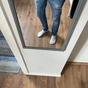 Dondup George , stl 32 - Säljer ett par blå skinny jeans från Dondup i storlek 32. Jeansen har slitningar och ett hål på ena låret för en trendig look. Klassisk femficksmodell med snygga detaljer och smal passform. Perfekta för dig som gillar en modern stil.