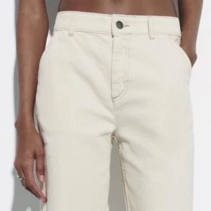 Vida jeans i offwhite från Zara - Stl 38 nya Snygga offwhite jeans från Zara med rak och vid passform. Jeansen har klassisk femficksdesign, hög midja och stängs med knapp och dragkedja. Perfekta för en clean och trendig look. Materialet är bomull med lite stretch för extra komfort.