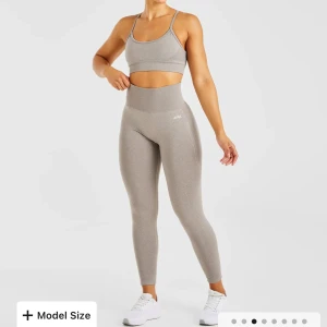Beige leggings från AYBL - EMPOWER SEAMLESS LEGGINGS Snygga beiha leggings från AYBL med hög midja och tight passform. Perfekta för träning med sin stretchiga och bekväma design. Diskret logga på sidan ger en stilren look.  Helt nya 300kr