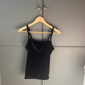 Svart sammetstopp - Snygg svart sammetstopp med smala axelband. Perfekt för en stilren look. Toppen är ärmlös och har en mjuk känsla tack vare sammetstyget.💕