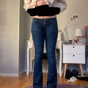 Blå bootcut jeans från NLY Jeans - Snygga blå bootcut jeans från NLY Jeans. De har en klassisk femficksdesign och en knappgylf. Perfekta för en stilren look med en touch av retro. Passar bra till både sneakers och klackar.