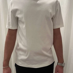 JLindeberg T-Shirt - Säljer en vit JLindeberg T-Shirt med riktigt skönt material!! T-Shirten är i nyskick, jag köpte den ny för 1000kr hos JLindeberg! Säljer nu för 399kr! Skön T-Shirt till sommaren med en snygg diskret JLindeberg logga på halsen!! Passar M eller lite större S!