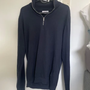 Marinblå halfzip från Lindbergh - Snygg Marinblå halfzip från Lindbergh med dragkedja vid halsen. Perfekt för en stilren look. Tröjan har långa ärmar och en ribbad krage som ger extra komfort.