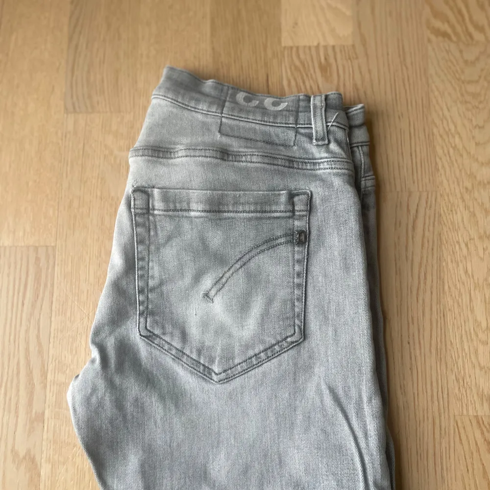 Snygga grå jeans från Dondup med en skinny passform. Tillverkade i Italien, dessa jeans har en klassisk femficksdesign och en stilren look. Perfekta för en trendig vardagsstil. De har ett litet hål mellan benen(se bild 3). Farkut & Housut.