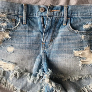 Blå jeansshorts med fransar - Super snygga lågmidjade shorst me super fina detaljer och fickor. Midjemått 73 🩵