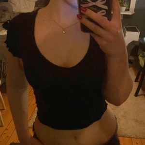 Svart kortärmad topp från H&M - Säljer en svart kortärmad topp från H&M