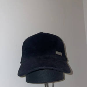 Svart keps från Max Mara - Keps från maggiore, nypris 549kr. I ganska bra skick. Denna keps är en riktig brudmagnet, passar perfekt för soliga dar eller bara dagligen för att dölja ens fula frisyr från Haga barber. Står ej för frakt problem .
