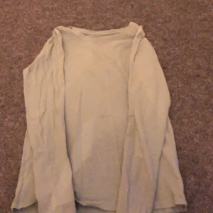 Grön långärmad tröja från Lager 157 - Säljer en enkel och bekväm grön långärmad tröja från 157. Tröjan är tillverkad i 100% bomull, vilket gör den mjuk och skön att bära. Perfekt för vardagsbruk!