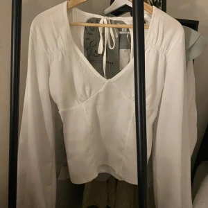 Vit blus med knytband - Snygg blus från Gina tricot med öppen rygg- inga deffekter!