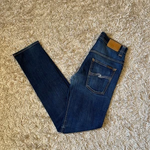 Mörkblåa jeans från Nudie Jeans slim fit  - Snygga blå jeans från Nudie jeans, med en slim passform. Fint skick, förutom att de är lite slitna i grenen, bild kan skickas privat . Storlek 31/34 mått kan såklart skickas vid osäkerhet. En riktigt skön wash på dessa, Postas antigen samma dag som köp eller dagen därpå, sänker priset 50kr vid snabb och smidig affär 💯🙌