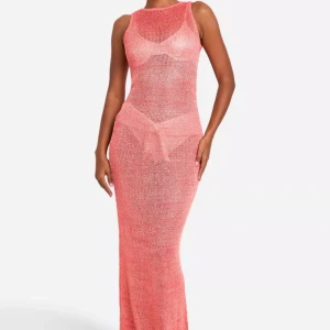 Rosa glittrig stickad långklänning - Snygg rosa stickad långklänning med glittrande detaljer/paljetter. Klänningen är ärmlös och har en figurnära passform. Klänningen har små ”diamanter” nedtill, se bild 4. Oavnvänd med prislapp