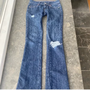 Lågmidjade slitna jeans - Så sjukt snygga jeans med bootcut och superlåg midja, samt slitningar! Köpt begagnat så går ej att köpa längre!!