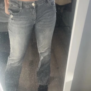 Grå jeansbyxor - Snygga grå jeansbyxor med en klassisk femficksdesign. De har en normal passform och är perfekta för en avslappnad stil. Byxorna har en knapp och dragkedja framtill.