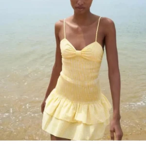 Gul kortklänning med volang - SÄLJER DENNA SLUTSÅLDA GULA KLÄNNING FRÅN ZARA bra skick!!!  och S!Söt gul kortklänning med smala axelband och volangdetaljer. Klänningen har en knytning i ryggen och ett rutigt mönster. Perfekt för sommarens varma dagar!