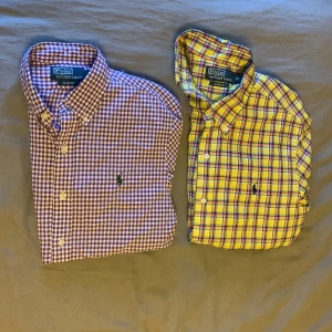 Två rutiga skjortor från Polo Ralph Lauren - Säljer två snygga rutiga skjortor från Polo Ralph Lauren. Den ena är lila och vit, den andra gul och röd. Båda har knappar och en klassisk krage. Perfekta för en stilren look! Går lätt att resella för 200-400 kr styck!!!! Den gula är storlek M medans den andra är storlek S.