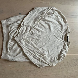 Beige långärmad tröja från  - Säljer en stilren beige långärmad tröja från matinique . Perfekt för en avslappnad look. Tröjan har en rund halsringning och är tillverkad i ett mjukt material som känns skönt mot huden.