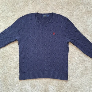 Marinblå Kabelstickad Ralph Lauren tröja - Stl L - Hej säljer en jättesnygg kabelstickad tröja från Ralph Lauren. Skicket är 8,5/10 Fint skick utan defekter. Stl L. Marinblå. Hör av dig om du har frågor eller vill ha fler bilder. Mvh Galgen 🤗