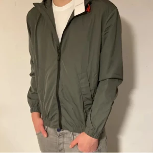 Helt ny windbreaker från Zadig Voltaire  - Säljer en grön vindjacka från Zadig Voltaire med huva och dragkedja. Jackan har elastiska muddar och fickor på sidorna. Perfekt ny till våren! Tagsen sitter kvar och förpackningen är oöppnad. Pris kan diskuteras vid snabb affär! Nypris 4000, mitt pris endast 1599!!