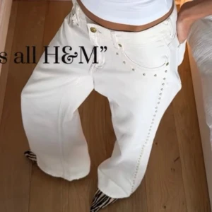 Vita byxor med nitar från H&M - Snygga vita byxor från H&M med guldnitar längs sidorna. De har en cool, bred, baggy passform. Storlek 36. Dom är helt i nyskick, säljer eftersom jag beställde fel storlek. Dom är slutsålda på hemsidan.