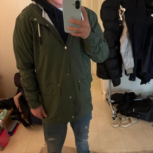 Regnjacka herr - Säljer en grön regnjacka |Passar bra till jeans och sneakers för en avslappnad look | storlek M | väldigt tunn och perfekt nu till våren | tveka inte alls vid funderingar eller intresse