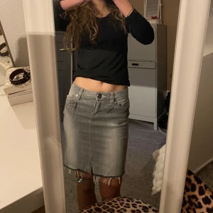 Grå jeanskjol - Snygg grå jeanskjol med slitna kanter och klassisk femficksdesign. 