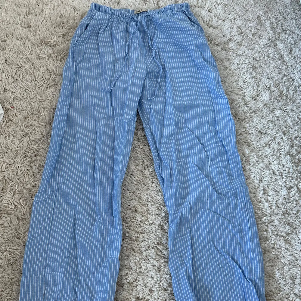 Snygga blå linnebyxor med vita ränder från Gina Tricot. De har en avslappnad passform och dragsko i midjan för extra komfort. Perfekta för sommaren. ❤️Dem är heller inte använda. Skriv för mer bilder❤️. Farkut & Housut.