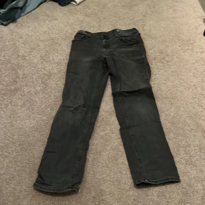 Svarta slim fit jeans från H&M - Snygga svarta slim fit jeans från H&M med justerbar midja. Perfekta för en stilren look. Klassisk femficksdesign och dragkedja i gylfen.