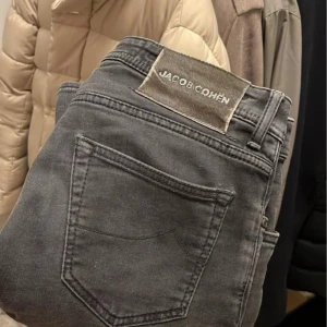  Jacob Cohën jeans - Snygga grå jeans från Jacob Cohën med klassisk femficksdesign. De har en knappgylf och är tillverkade i italien. Defekter syns på bild, lagade små hål som inte syns vid användning, ny modell