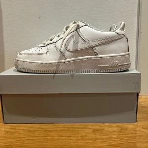 Vita Nike Air Force sneakers - Säljer ett par klassiska vita Nike Air Force sneakers. De har en stilren design med snörning och en bekväm. Skornas skick är i 7/10. Köpta för 1400, säljer för 500. Kommer med original box.