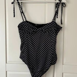 Svart prickig body från Zara - Snygg svart body från Zara med vita prickar och knytbara axelband. 