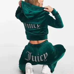 Grön hoodie från Juicy Couture - Snygg grön hoodie från Juicy Couture i mjukt sammetstyg. Hoodien har en glittrig Juicy-logga på ryggen och en bekväm passform. Perfekt för en avslappnad stil med en touch av glamour. Samt byxor på köpet. (Köpt för cirka 2200kr)