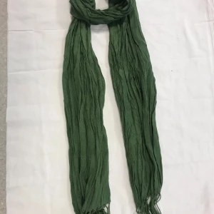 Grön halsduk - Snygg grön halsduk med fransar i ändarna. Perfekt för att ge en färgklick till din outfit. Den är lätt och kan enkelt stylas på olika sätt.  Finns svart, mörk röd , brun, blå färg kvar 