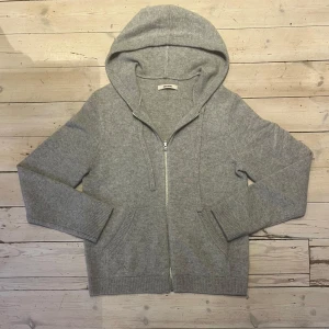 100% Kashmir Zadig & Voltaire zip hoodie (Ny) - Säljer en trendig grå hoodie från Zadig & Voltaire. Den har en dragkedja framtill och en snygg detalj med pilar på ärmen. Skannar man QR koden kommer man direkt till Z&Vs riktiga hemsida. Det finns inte några defekter och hoodien är gjord av 100% Kashmir. Skick: 10/10  Nypris: ca 6000kr