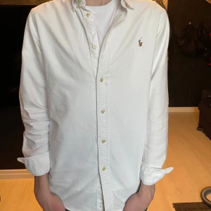 Vit Ralph Lauren Skjorta - Tja, säljer min stilrena vita Ralph Lauren skjorta som är helt oanvänd. Skjortan är storlek Small och passar någon som är 175-180 ish. Tar gärna emot frågor och funderingar. Pris kan ändras vid snabb affär!😃